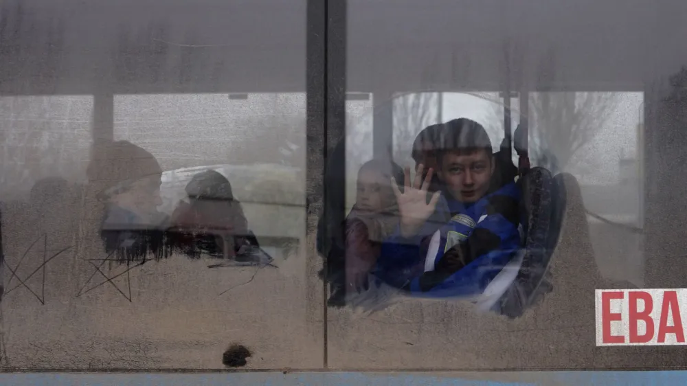 A boy waves as he leaves on an evacuation bus, after Russia's military retreat from Kherson, at the central bus station in Kherson, Ukraine November 24, 2022. REUTERS/Murad Sezer   TPX IMAGES OF THE DAY