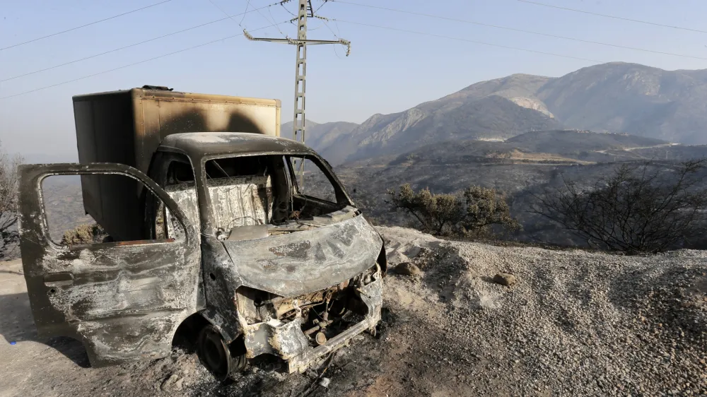 FILE - A charred truck is pictured after a fire near the village of Achlouf, in the Kabyle region, east of Algiers, Friday, Aug. 13, 2021. An Algerian court sentenced 49 people to death Thursday, Nov. 24, 2022 for the brutal mob killing of a painter wrongly suspected of starting devastating wildfires. In fact the man had come to help fight the fires. The 49 people will likely serve life in prison instead because Algeria has a moratorium on executions. (AP Photo/Toufik Doudou, File)