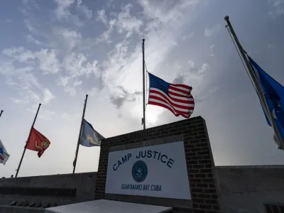 FILE In this photo reviewed by U.S. military officials, flags fly at half-staff at Camp Justice, Aug. 29, 2021, in Guantanamo Bay Naval Base, Cuba. The Defense Department says Sufiyan Barhoumi, an Algerian man imprisoned at the Guantanamo Bay detention center for nearly 20 years, has been released and sent back to his homeland. (AP Photo/Alex Brandon, File)