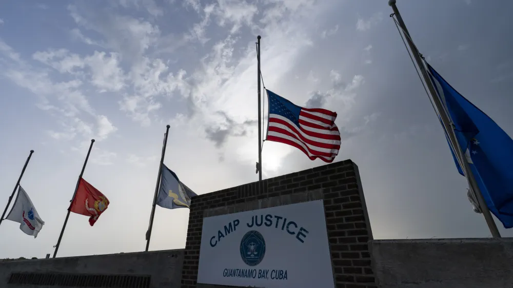 FILE In this photo reviewed by U.S. military officials, flags fly at half-staff at Camp Justice, Aug. 29, 2021, in Guantanamo Bay Naval Base, Cuba. The Defense Department says Sufiyan Barhoumi, an Algerian man imprisoned at the Guantanamo Bay detention center for nearly 20 years, has been released and sent back to his homeland. (AP Photo/Alex Brandon, File)