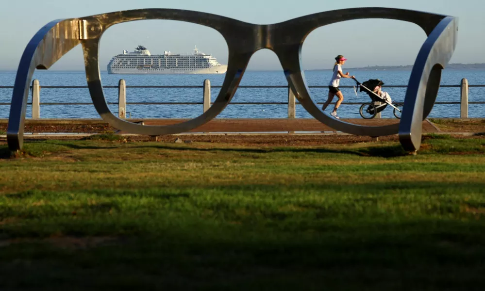 A lady runs with a pram along the Sea Point Promenade as The World, an exclusive private residential ship during its 2024 journey to six continents, arrives in Cape Town, South Africa, February 28, 2024. REUTERS/Esa Alexander   TPX IMAGES OF THE DAY