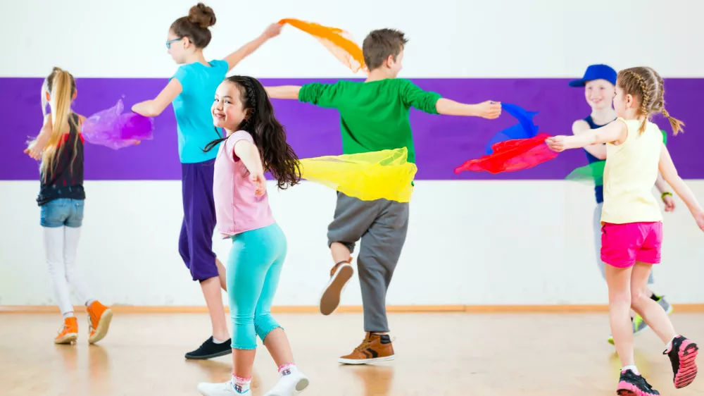 E8N634 Children dancing modern group choreography with scarfs