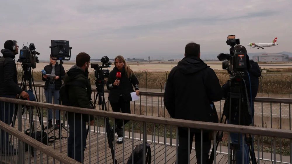 Journalists gather after a commercial airplane flying from Morocco to Turkey made an emergency landing in Barcelona's El Prat airport in the early hours and 28 would-be migrants on board ran away across the tarmac in Barcelona, Spain December 7, 2022. REUTERS/Nacho Doce