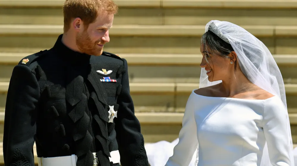 FILE - Prince Harry and Meghan Markle walk down the steps after their wedding at St. George's Chapel in Windsor Castle in Windsor, near London, England, Saturday, May 19, 2018. Britain's monarchy is bracing for more bombshells to be lobbed over the palace gates Thursday, Dec. 8, 2022 as Netflix releases the first three episodes of a series that promises to tell the "full truth" about Prince Harry and Meghan's estrangement from the royal family. (Ben Birchhall/pool photo via AP, file)