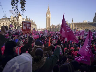 Royal Mail workers hold placards and banners as they gather in Parliament Square, to hold a protest over pay and jobs, in London, Friday, Dec. 9, 2022. The Communications Workers Union (CWU) has planned six days of strike over pay. (AP Photo/Alberto Pezzali)