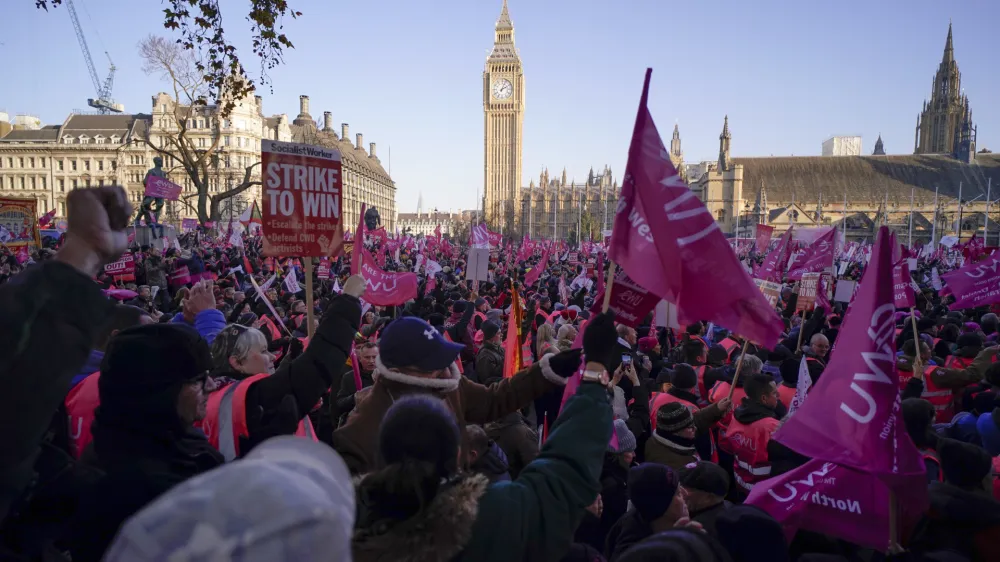 Royal Mail workers hold placards and banners as they gather in Parliament Square, to hold a protest over pay and jobs, in London, Friday, Dec. 9, 2022. The Communications Workers Union (CWU) has planned six days of strike over pay. (AP Photo/Alberto Pezzali)