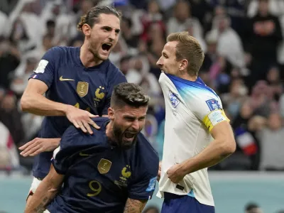 France's Adrien Rabiot, top, and France's Olivier Giroud celebrate after England's Harry Kane missed a penalty kick during the World Cup quarterfinal soccer match between England and France, at the Al Bayt Stadium in Al Khor, Qatar, Saturday, Dec. 10, 2022. (AP Photo/Frank Augstein)