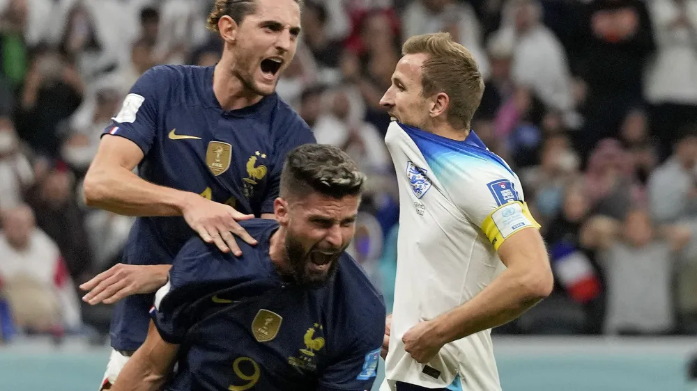 France's Adrien Rabiot, top, and France's Olivier Giroud celebrate after England's Harry Kane missed a penalty kick during the World Cup quarterfinal soccer match between England and France, at the Al Bayt Stadium in Al Khor, Qatar, Saturday, Dec. 10, 2022. (AP Photo/Frank Augstein)