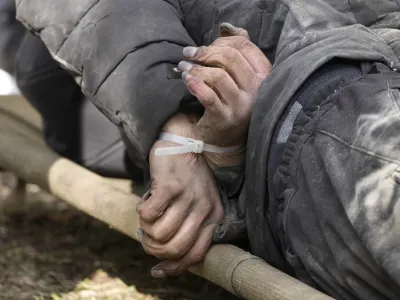 A dead civilian with his hands tied behind his back lies on the ground in Bucha close to Kyiv, Ukraine, Monday April 4, 2022. Russia is facing a fresh wave of condemnation after evidence emerged of what appeared to be deliberate killings of civilians in Ukraine. (AP Photo/Efrem Lukatsky)