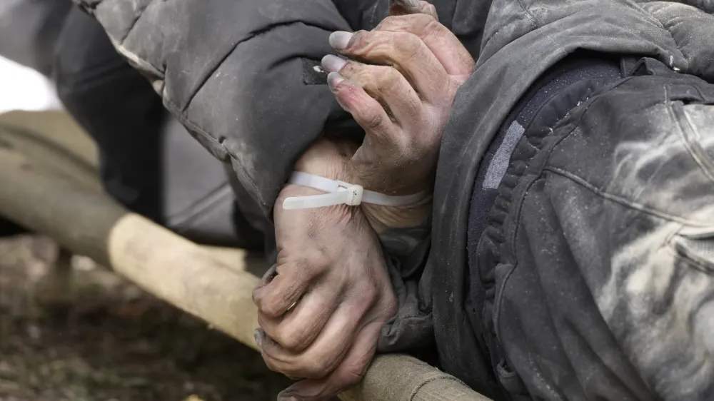 A dead civilian with his hands tied behind his back lies on the ground in Bucha close to Kyiv, Ukraine, Monday April 4, 2022. Russia is facing a fresh wave of condemnation after evidence emerged of what appeared to be deliberate killings of civilians in Ukraine. (AP Photo/Efrem Lukatsky)