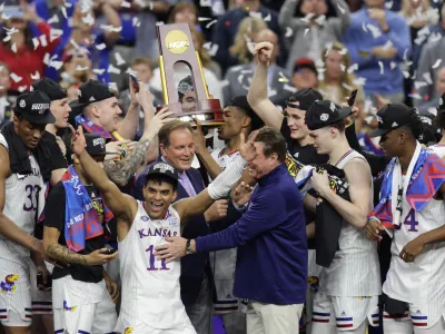 Apr 4, 2022; New Orleans, LA, USA; Kansas Jayhawks guard Remy Martin (11) celebrates as head coach Bill Self (middle right) reacts after defeating the North Carolina Tar Heels during the 2022 NCAA men's basketball tournament Final Four championship game at Caesars Superdome. Mandatory Credit: Stephen Lew-USA TODAY Sports