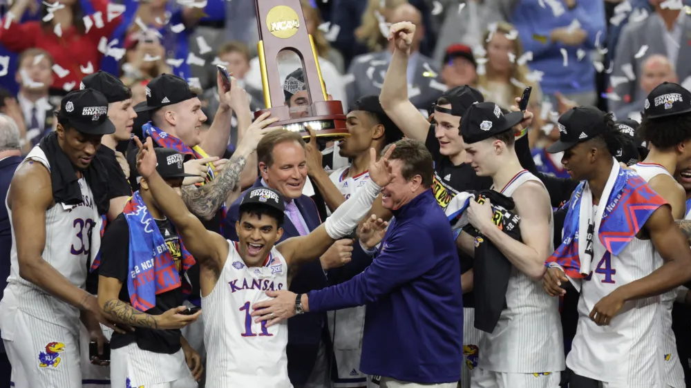 Apr 4, 2022; New Orleans, LA, USA; Kansas Jayhawks guard Remy Martin (11) celebrates as head coach Bill Self (middle right) reacts after defeating the North Carolina Tar Heels during the 2022 NCAA men's basketball tournament Final Four championship game at Caesars Superdome. Mandatory Credit: Stephen Lew-USA TODAY Sports