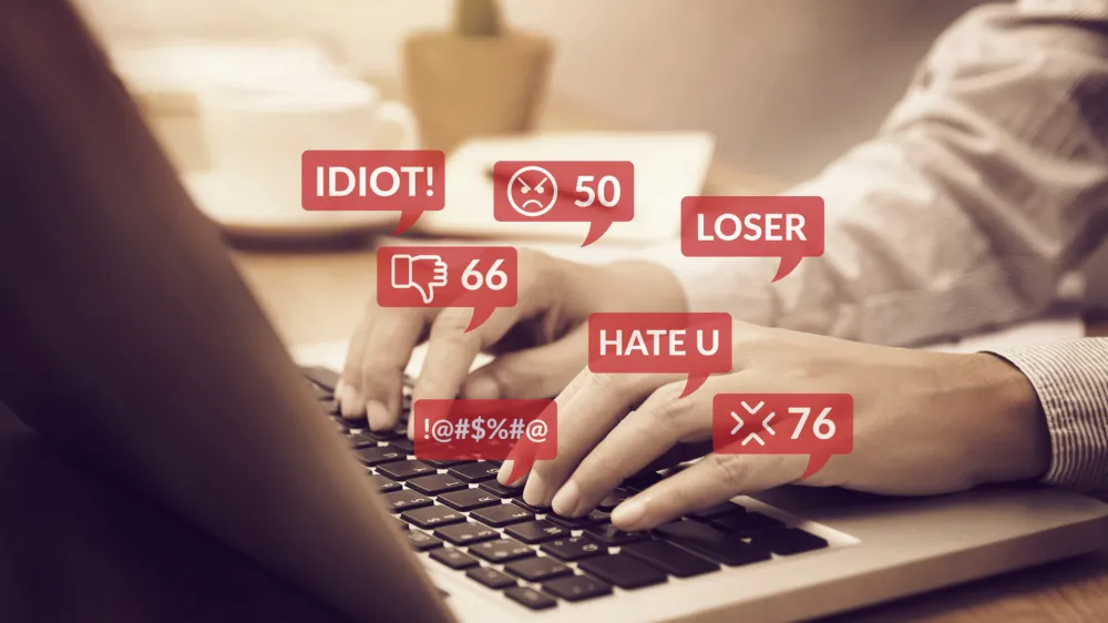 ﻿cyber bullying concept. people using notebook computer laptop for social media interactions with notification icons of hate speech and mean comment in social network