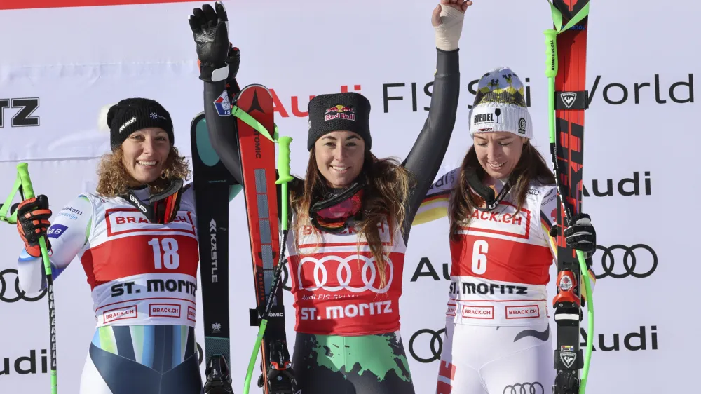 From left, second placed Slovenia's Ilka Stuhec, the winner Italy's Sofia Goggia, and third placed Germany's Kira Weidle celebrate on podium after an alpine ski, women's World Cup downhill race, in St. Moritz, Switzerland, Saturday, Dec. 17, 2022. (AP Photo/Marco Trovati)