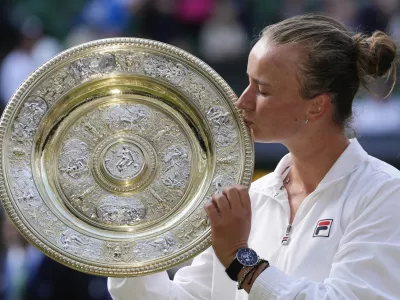 Barbora Krejcikova of the Czech Republic kisses her trophy after defeating Jasmine Paolini of Italy in the women's singles final at the Wimbledon tennis championships in London, Saturday, July 13, 2024. (AP Photo/Kirsty Wigglesworth)