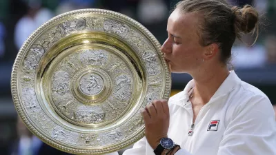 Barbora Krejcikova of the Czech Republic kisses her trophy after defeating Jasmine Paolini of Italy in the women's singles final at the Wimbledon tennis championships in London, Saturday, July 13, 2024. (AP Photo/Kirsty Wigglesworth)