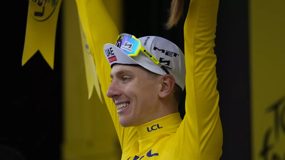 Stage winner Slovenia's Tadej Pogacar, wearing the overall leader's yellow jersey, celebrates on the podium after the fourteenth stage of the Tour de France cycling race over 151.9 kilometers (94.4 miles) with start in Pau and finish in Saint-Lary-Soulan Pla d'Adet, France, Saturday, July 13, 2024. (AP Photo/Jerome Delay)