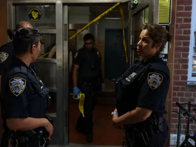 NYPD officers stand outside a blood stained entrance, where according to police reports a shooting injured one man who was transported in stable condition, outside a New York City Housing Authority public housing building in the Canarsie section of the Brooklyn borough of New York City, U.S., July 11, 2022. REUTERS/Shannon Stapleton