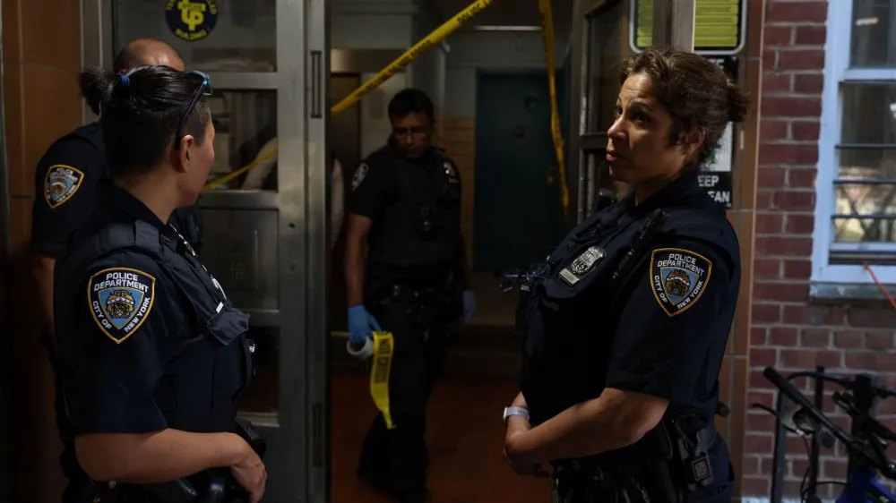 NYPD officers stand outside a blood stained entrance, where according to police reports a shooting injured one man who was transported in stable condition, outside a New York City Housing Authority public housing building in the Canarsie section of the Brooklyn borough of New York City, U.S., July 11, 2022. REUTERS/Shannon Stapleton