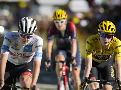 Slovenia's Tadej Pogacar, wearing the best young rider's white jersey, Britain's Geraint Thomas and Denmark's Jonas Vingegaard, wearing the overall leader's yellow jersey, cross the finish line of the twelfth stage of the Tour de France cycling race over 165.5 kilometers (102.8 miles) with start in Briancon and finish in Alpe d'Huez, France, Thursday, July 14, 2022. (AP Photo/Thibault Camus)