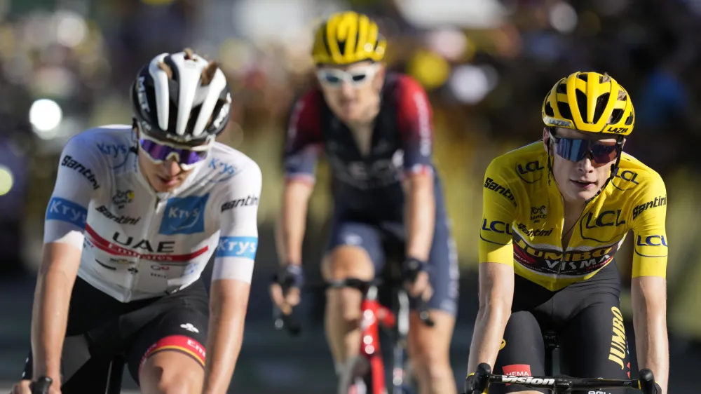 Slovenia's Tadej Pogacar, wearing the best young rider's white jersey, Britain's Geraint Thomas and Denmark's Jonas Vingegaard, wearing the overall leader's yellow jersey, cross the finish line of the twelfth stage of the Tour de France cycling race over 165.5 kilometers (102.8 miles) with start in Briancon and finish in Alpe d'Huez, France, Thursday, July 14, 2022. (AP Photo/Thibault Camus)