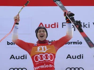 Switzerland's Marco Odermatt celebrates on the podium after winning an alpine ski, men's World Cup Super G race, in Bormio, Italy, Thursday, Dec.29, 2022. (AP Photo/Alessandro Trovati)