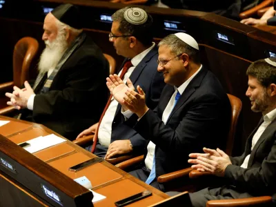 Right-wing Knesset members Itamar Ben-Gvir and Bezalel Smotrich clap as they attend a special session at the Knesset Israel's parliament, to approve and swear in a new right-wing government, in Jerusalem December 29, 2022. REUTERS/Amir Cohen/Pool