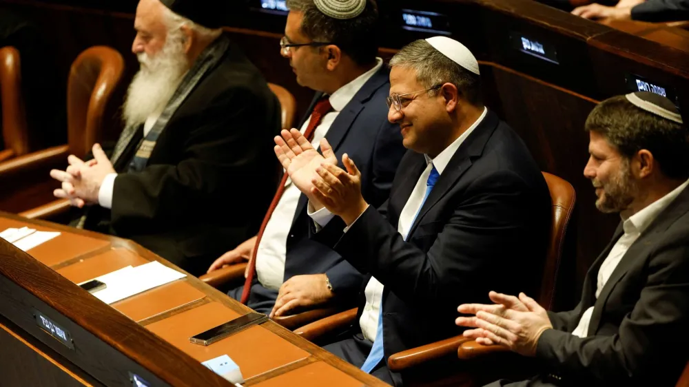 Right-wing Knesset members Itamar Ben-Gvir and Bezalel Smotrich clap as they attend a special session at the Knesset Israel's parliament, to approve and swear in a new right-wing government, in Jerusalem December 29, 2022. REUTERS/Amir Cohen/Pool