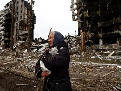 A woman carries her cat as she walks past buildings that were destroyed by Russian shelling, amid Russia's invasion of Ukraine in Borodyanka, in the Kyiv region, Ukraine, April 5, 2022.    REUTERS/Zohra Bensemra/File Photo    TPX IMAGES OF THE DAY    SEARCH "GLOBAL POY" FOR THIS STORY. SEARCH "REUTERS POY" FOR ALL BEST OF 2022 PACKAGES.