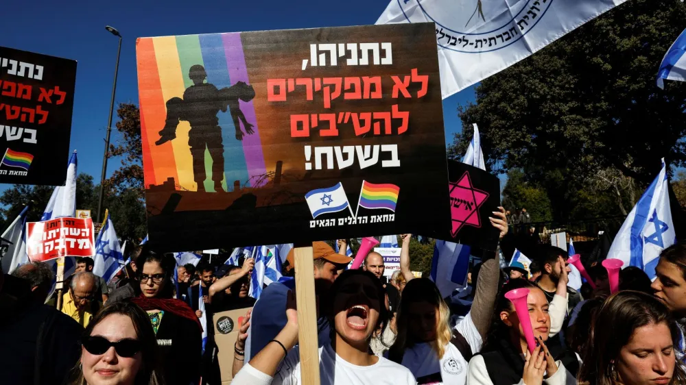 An Israeli holds a sign which says in Hebrew "Netanyahu, we don't abandon LGBTQ's in the field" at a protest outside the Knesset, Israel's parliament, on the day the new right-wing government is sworn in, with Benjamin Netanyahu as Prime Minister, in Jerusalem December 29, 2022. REUTERS/Ammar Awad