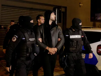 Andrew Tate and Tristan Tate are escorted by police officers outside the headquarters of the Directorate for Investigating Organized Crime and Terrorism in Bucharest (DIICOT) after being detained for 24 hours, in Bucharest, Romania, December 29, 2022. Inquam Photos/Octav Ganea via REUTERS ATTENTION EDITORS - THIS IMAGE WAS PROVIDED BY A THIRD PARTY. ROMANIA OUT. NO COMMERCIAL OR EDITORIAL SALES IN ROMANIA