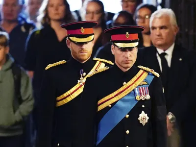 Prince William, the prince of Wales, right, and Prince Harry attend the vigil of the Queen's grandchildren around the coffin, as it lies in state on the catafalque in Westminster Hall, at the Palace of Westminster, London, Saturday, Sept. 17, 2022, ahead of her funeral on Monday. (Aaron Chown/Pool Photo via AP)