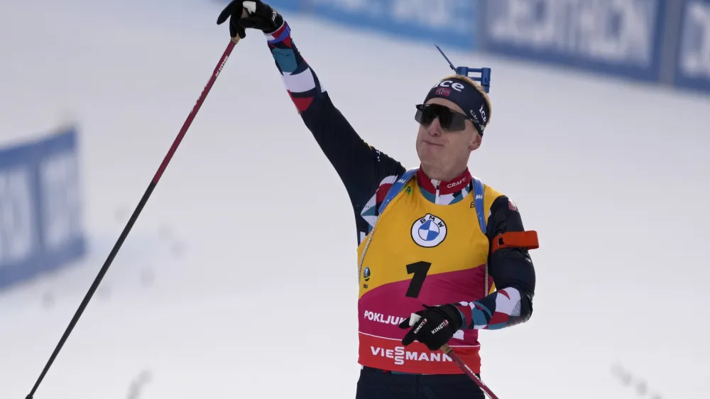 Johannes Thingnes Boe, of Norway, celebrates as he crosses the finish line to win the men 12.5 km pursuit competition at the Biathlon World Cup event in Pokljuka, Slovenia, Saturday, Jan. 7, 2023. (AP Photo/Darko Bandic)