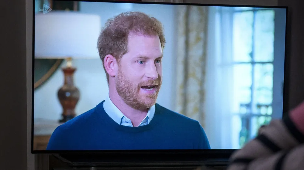 A person at home in Edinburgh watches Prince Harry, the Duke of Sussex, being interviewed by ITV's Tom Bradby, during "Harry: The Interview," two days before his controversial autobiography "Spare" is published, Sunday, Jan. 8, 2023. (Jane Barlow/PA via AP)