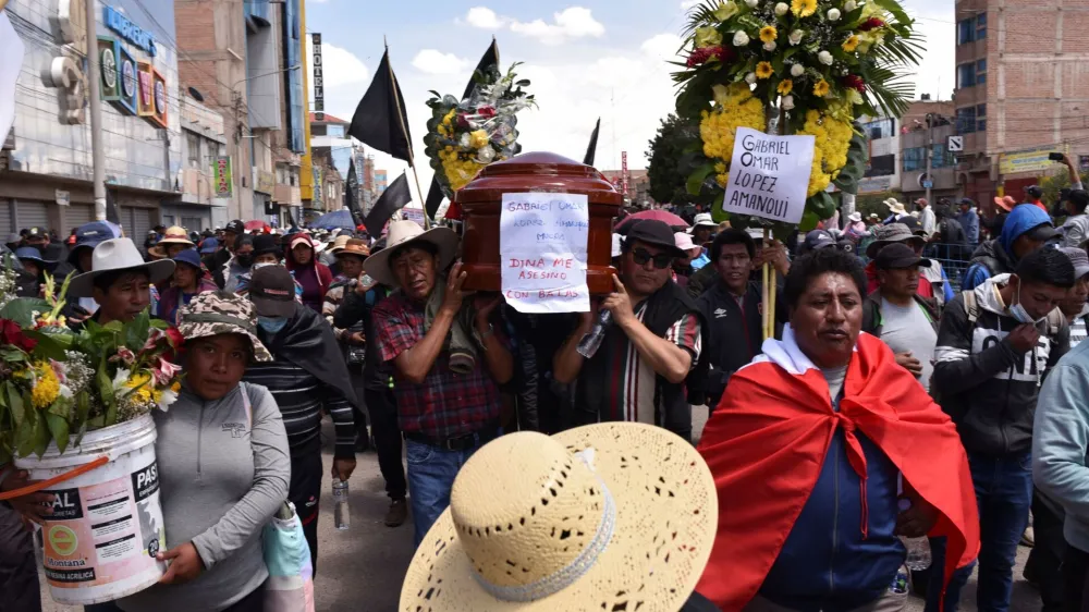 People walk while carrying the coffin of a man, who died in violent clashes earlier this week, ignited by the ouster of leftist President Pedro Castillo, in Juliaca, Peru January 11, 2023. REUTERS/Pedro Anza NO RESALES. NO ARCHIVES