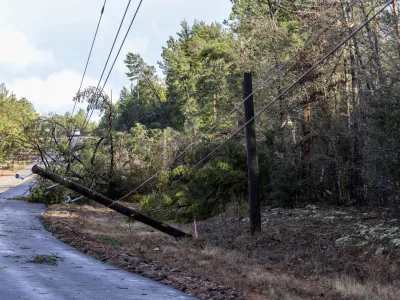 Trees and powerlines are down on County Road 40 in the aftermath from severe weather, Thursday, Jan. 12, 2023, in Prattville, Ala. A giant, swirling storm system billowing across the South spurred a tornado on Thursday that shredded the walls of homes, toppled roofs and uprooted trees in Selma, Alabama, a city etched in the history of the civil rights movement.(AP Photo/Vasha Hunt)