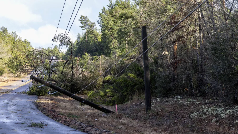 Trees and powerlines are down on County Road 40 in the aftermath from severe weather, Thursday, Jan. 12, 2023, in Prattville, Ala. A giant, swirling storm system billowing across the South spurred a tornado on Thursday that shredded the walls of homes, toppled roofs and uprooted trees in Selma, Alabama, a city etched in the history of the civil rights movement.(AP Photo/Vasha Hunt)