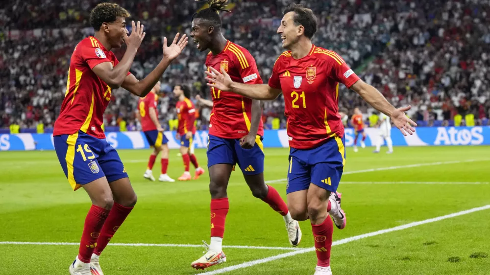 Spain's Mikel Oyarzabal celebrates with Nico Williams and Lamine Yamal, left, after scoring his side's second goal during the final match between Spain and England at the Euro 2024 soccer tournament in Berlin, Germany, Sunday, July 14, 2024. (AP Photo/Manu Fernandez)