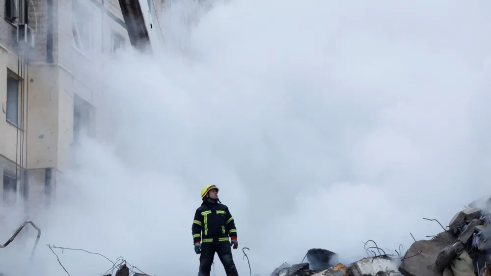 An emergency personnel looks on at the site where an apartment block was heavily damaged by a Russian missile strike, amid Russia's attack on Ukraine, in Dnipro, Ukraine January 15, 2023. REUTERS/Clodagh Kilcoyne