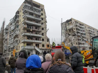 15 January 2023, Ukraine, Dnipro: People watch as rescuers search for survivors at an apartment block hit by Russian rockets during a massive missile attack on Dnipro. Photo: -/Ukrinform/dpa