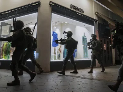 Israeli security forces search for assailants near the scene of a shooting attack in Tel Aviv, Israel, Thursday, April 7, 2022. Israeli health officials say two people were killed and at least eight others wounded in a shooting in central Tel Aviv. The shooting on Thursday evening, the fourth attack in recent weeks, occurred in a crowded area with several bars and restaurants. (AP Photo/Ariel Schalit)