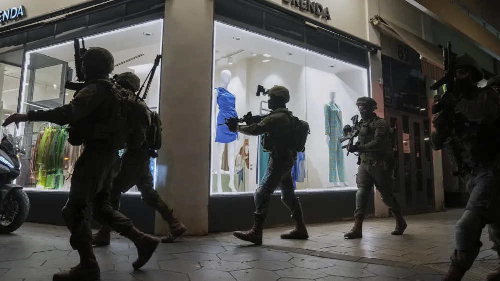 Israeli security forces search for assailants near the scene of a shooting attack in Tel Aviv, Israel, Thursday, April 7, 2022. Israeli health officials say two people were killed and at least eight others wounded in a shooting in central Tel Aviv. The shooting on Thursday evening, the fourth attack in recent weeks, occurred in a crowded area with several bars and restaurants. (AP Photo/Ariel Schalit)