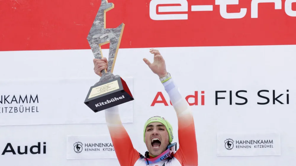 Alpine Skiing - FIS Alpine Ski World Cup - Men's Slalom - Kitzbuehel, Austria - January 22, 2023 Switzerland's Daniel Yule celebrates with the trophy on the podium after winning the men's slalom REUTERS/Leonhard Foeger