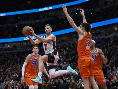 Chicago Bulls guard Goran Dragic (7) passes the ball away from between Oklahoma City Thunder center Mike Muscala (33), forward Darius Bazley, back, and guard Josh Giddey (3) during the second half of an NBA basketball game Friday, Jan. 13, 2023, in Chicago. (AP Photo/Matt Marton)