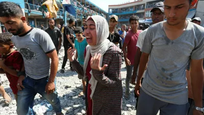 A Palestinian woman reacts at the site of an Israeli air strike on a UN school sheltering displaced people, amid the Israel-Hamas conflict, in Nusairat in central Gaza Strip, July 14, 2024. REUTERS/Ramadan Abed