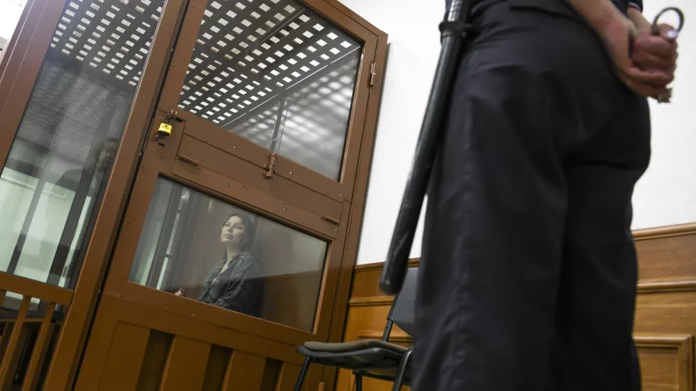 FILE - Ksenia Karelina, also known by the last name of Khavana, sits in a defendant's cage in a court in Yekaterinburg, Russia, on Thursday, June 20, 2024. The dual Russian-U.S. citizen was arrested on treason charges in Yekaterinburg in February after returning from Los Angeles to visit relatives, and the charges reportedly stem from her $51 donation to a U.S. charity that helps Ukraine. (AP Photo, File)