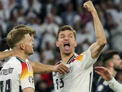 FILE - Germany's Thomas Mueller, right, celebrates during the Group A match between Germany and Scotland at the Euro 2024 soccer tournament in Munich, Germany, Friday, June 14, 2024. Germany forward Thomas Müller has announced his retirement from international soccer after a 14-year career that included the 2014 World Cup title. (Christian Charisius/dpa via AP, File)