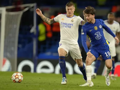 Real Madrid's Toni Kroos, left, challenges for the ball with Chelsea's Mason Mount during a Champions League first-leg quarterfinal soccer match between Chelsea and Real Madrid at Stamford Bridge stadium in London, Wednesday, April 6, 2022. (AP Photo/Kirsty Wigglesworth)