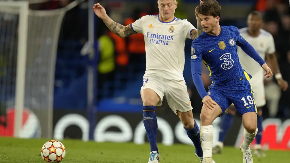 Real Madrid's Toni Kroos, left, challenges for the ball with Chelsea's Mason Mount during a Champions League first-leg quarterfinal soccer match between Chelsea and Real Madrid at Stamford Bridge stadium in London, Wednesday, April 6, 2022. (AP Photo/Kirsty Wigglesworth)