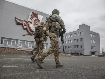 Ukrainian servicemen walk at the Chernobyl nuclear plant, in Chernobyl, Ukraine, Tuesday, April 5, 2022. (AP Photo/Oleksandr Ratushniak)